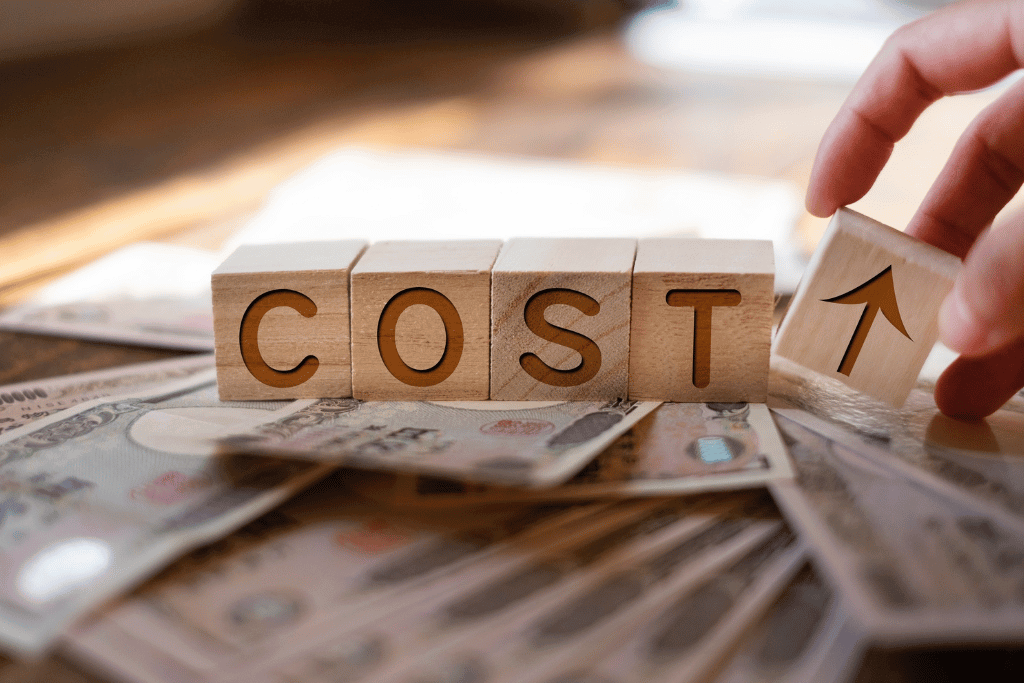 お金の上に置かれたCOSTのブロック
