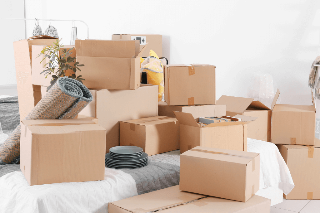 引っ越し準備中の部屋に積み上がったダンボールと荷物
